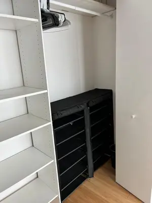 a closet with white shelves and a black cabinet at Fully Equipped Modern Loft in the heart of Miami in Miami