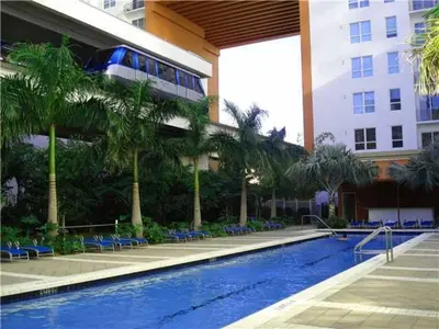 a hotel with a swimming pool with chairs and a building at Fully Equipped Modern Loft in the heart of Miami in Miami