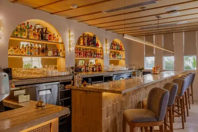 a bar with a row of bar stools at Donatella Boutique Hotel in Miami Beach