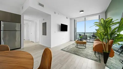 a living room with a table and chairs and a tv at 2-Bedr Downtown Miami Condo Bay Views in Miami