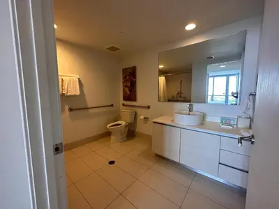 a bathroom with a sink and a toilet and a mirror at Cozy 1BR Retreat wPool BeachService & Full Kitchen in Hallandale Beach