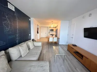 a living room with a white couch and a tv at Cozy 1BR Retreat wPool BeachService & Full Kitchen in Hallandale Beach