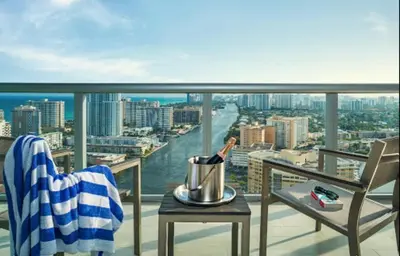 a bottle of wine on a table on a balcony at Cozy 1BR Retreat wPool BeachService & Full Kitchen in Hallandale Beach