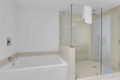 a white bathroom with a shower and a tub at Bay View 2Br Apartment with Amenities in Hollywood