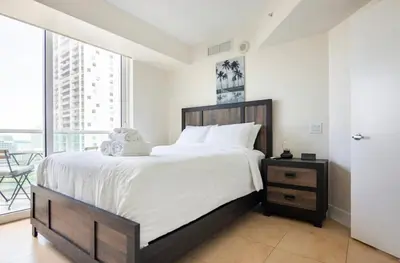 a bedroom with a large bed and a large window at BrickellRiver LOFT with parking & 12 min to South Beach in Miami