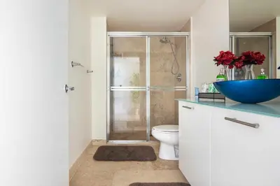 a bathroom with a toilet and a shower with a blue bowl at BrickellRiver LOFT with parking & 12 min to South Beach in Miami
