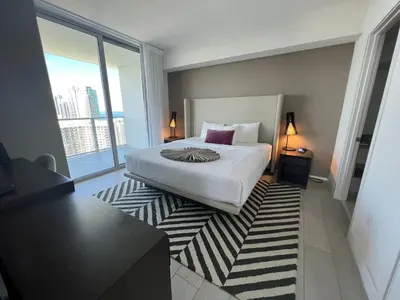 a bedroom with a bed and a large window at Apt Hyde, Beach, Pool, and Resort Amenities in Miami in Hollywood