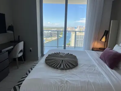 a bedroom with a large bed with a large window at Apt Hyde, Beach, Pool, and Resort Amenities in Miami in Hollywood