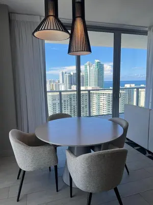 a dining table and chairs in a room with a window at Apt Hyde, Beach, Pool, and Resort Amenities in Miami in Hollywood