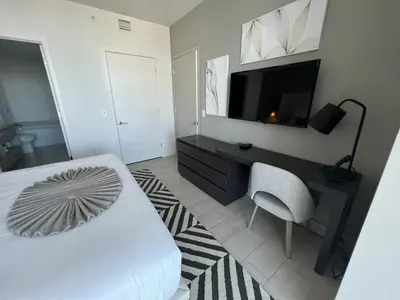 a bedroom with a bed and a tv and a chair at Hyde Luxury 2 Bedroom Apartment in Miami Beach and Pool in Hollywood