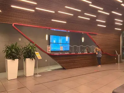 a woman standing at a counter in an airport at Studio with Service Beach and Pool Hallandale Beach in Hallandale Beach