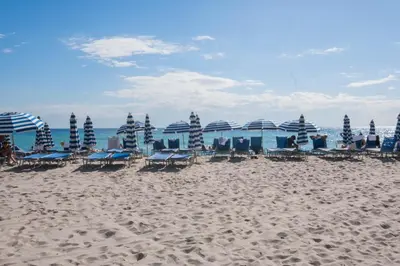 a group of chairs and umbrellas on a beach at Studio 2b 1b with Beach and Pool Miami Beach in Hallandale Beach