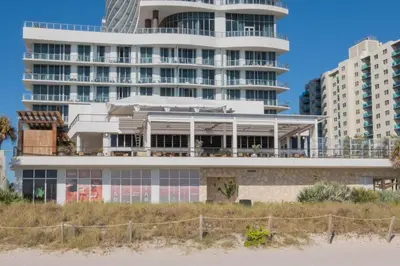 a building on the beach with buildings in the background at Studio 2b 1b with Beach and Pool Miami Beach in Hallandale Beach