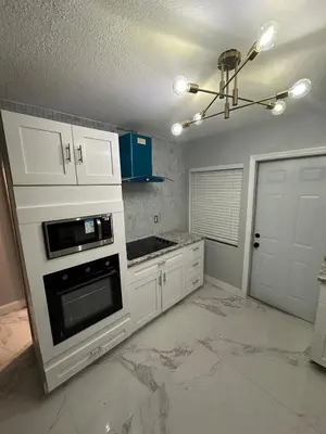 a kitchen with white cabinets and a stove at Luxury Entertainment home Hard rock stadium in Opa-locka