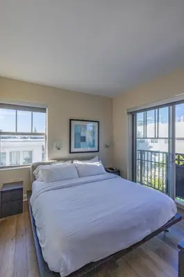 a large white bed in a bedroom with windows at Amazing 1 Bedroom with Rooftop Pool D309 in Miami Beach