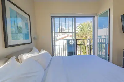 a bedroom with a white bed and a balcony at Amazing 1 Bedroom with Rooftop Pool D309 in Miami Beach