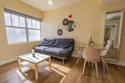 a living room with a couch and a table at Amazing 1 Bedroom with Rooftop Pool D304 in Miami Beach