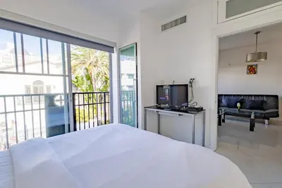 a white bedroom with a bed and a television at Beautiful 1 bedroom with Rooftop Pool D209 in Miami Beach