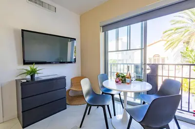 a living room with a table and chairs and a tv at Beautiful 1 bedroom with Rooftop Pool D209 in Miami Beach