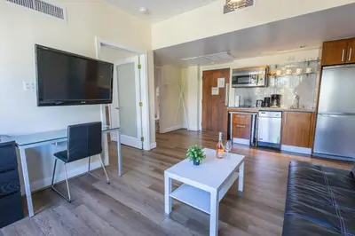 a living room with a table and a tv on the wall at Beautiful 1 Bedroom with Rooftop Pool D203 in Miami Beach