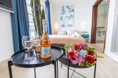 a bottle of wine and flowers on a table in a room at Studio with rooftop pool on Ocean Dr B303 in Miami Beach
