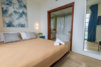 a bedroom with a large bed and a mirror at Studio with rooftop pool on Ocean Dr B303 in Miami Beach