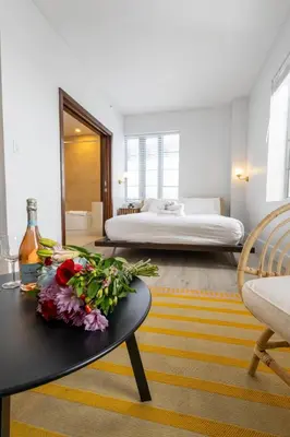 a bedroom with a bed and a table with flowers on it at Beautiful Studio with Rooftop pool B309 in Miami Beach