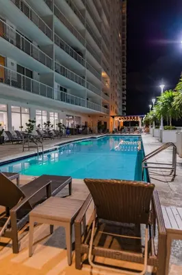 a swimming pool at night with chairs and a building at 1BR Brickell included Pool, Gym and Free Parking in Miami