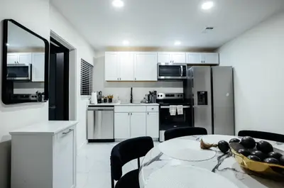 a kitchen with a table with a bowl of fruit on it at Miami Palms Serene in Miami