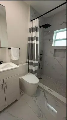 a white bathroom with a toilet and a shower at Miami Palms Serene in Miami