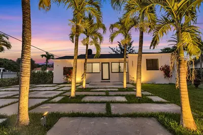 a house with palm trees in front of it at Miami Palms Serene in Miami