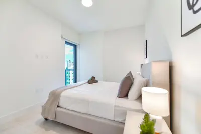 a white bedroom with a large bed and a window at Central Brickell Condo Walk to Shops & Dining in Miami