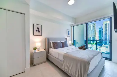 a bedroom with a large bed and a large window at Central Brickell Condo Walk to Shops & Dining in Miami