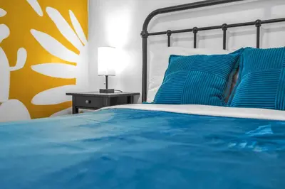 a bed with blue pillows and a yellow wall at Miami 3BR Cruise Port Calle 8 Brickell South Beach in Miami