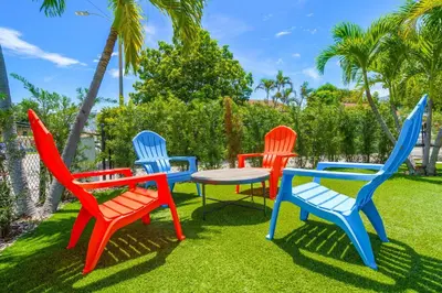 four colorful chairs and a table in the grass at Miami 3BR Cruise Port Calle 8 Brickell South Beach in Miami