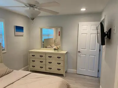 a bedroom with a bed and a dresser with a mirror at Private Room in Spacious 3-Bedroom Home in Fort Lauderdale