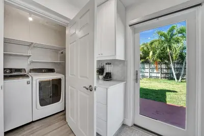 a kitchen with a washer and dryer next to a door at Private Room in Spacious 3-Bedroom Home in Fort Lauderdale