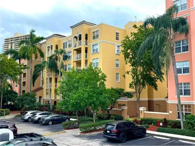 a parking lot with cars parked in front of buildings at Yacht Club Aventura 2 BR 2 Bath with Free Parking in Aventura