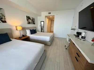 a hotel room with two beds and a kitchen at Studio 2 beds queen, pool, gym and service beach in Hallandale Beach