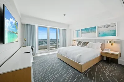 a white bedroom with a large bed and windows at Beachfront Ritz-Carlton Luxury 1BR Residence in Fort Lauderdale