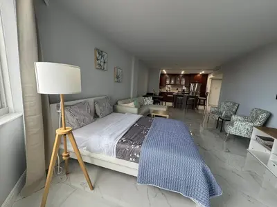 a bedroom with a bed with a lamp and a living room at Modern Apartments Ocean Reserve Sunny Isles Beach in Sunny Isles Beach