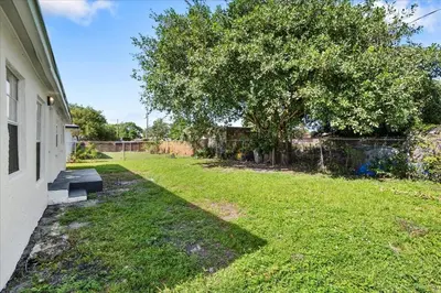 a yard with a tree next to a house at 4BR Escape Near Beach & Downtown in Fort Lauderdale