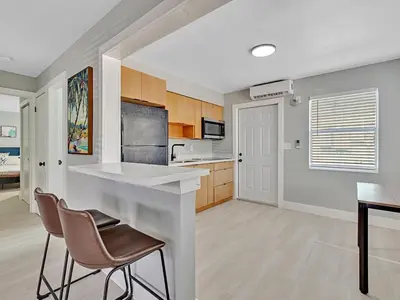 a kitchen with a counter and chairs in a room at North Hollywood Beach 1BR | Walk to Ocean in Dania Beach