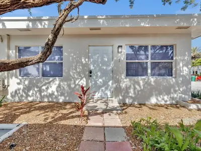 a white house with a tree in front of it at North Hollywood Beach 1BR | Walk to Ocean in Dania Beach