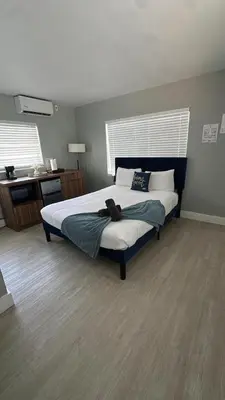 a bedroom with a large bed and a desk at Charming 1BR Escape Near Hollywood & Dania in Dania Beach