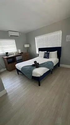 a bedroom with a large bed and a desk at Charming 1BR Escape Near Hollywood & Dania in Dania Beach