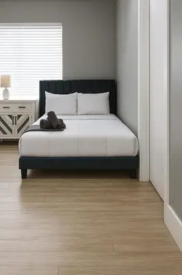 a bedroom with a bed with a black headboard at Hollywood Beach 1BR | Steps to Dania Beach in Dania Beach