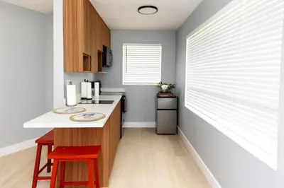 a kitchen with a white counter and a red stool at Hollywood Beach 1BR | Steps to Dania Beach in Dania Beach
