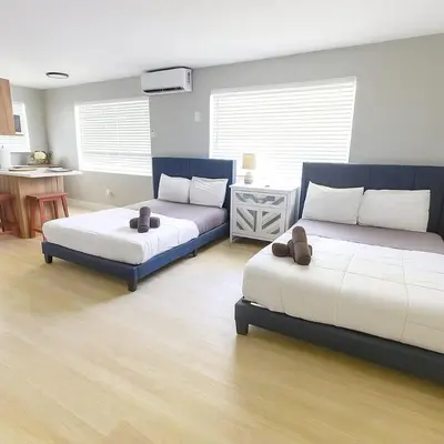a living room with two beds and a couch at Hollywood Beach 1BR | Steps to Dania Beach in Dania Beach