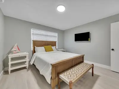 a bedroom with a bed and a television in it at Hollywood Beach 1BR Getaway | WiFi + AC in Dania Beach